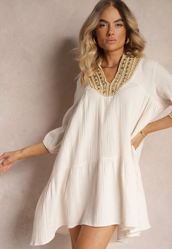 Renee - Beżowa Rozkloszowana Sukienka Mini Ozdobiona Plecionką Przy Dekolcie Rufta. Kolor: beżowy. Wzór: aplikacja. Sezon: lato. Typ sukienki: rozkloszowane. Styl: boho. Długość: mini