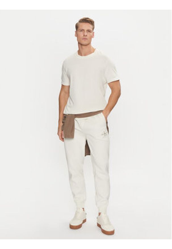 Calvin Klein Jeans Spodnie dresowe Monologo Hwk Pant J30J325658 Écru Regular Fit. Materiał: bawełna, syntetyk