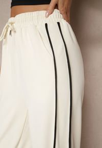 Renee - Jasnobeżowe Szerokie Spodnie Dresowe High Waist Zdobione Lampasami Sopaline. Okazja: na spacer. Stan: podwyższony. Kolor: beżowy. Materiał: dresówka. Wzór: aplikacja. Styl: sportowy, elegancki #5