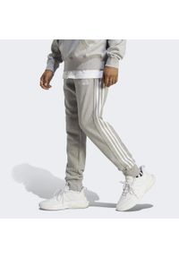 Adidas - Spodnie dresowe męskie adidas Essentials French Terry Tapered Cuff 3-Stripes. Kolor: biały, szary, wielokolorowy, fioletowy. Materiał: dresówka