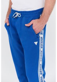 Guess - GUESS Niebieskie spodnie dresowe New Arlo Long Pant. Kolor: niebieski. Materiał: dresówka