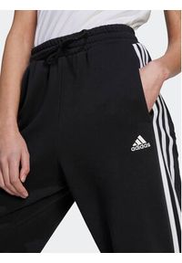 Adidas - adidas Spodnie dresowe Essentials 3-Stripes Open Hem Fleece HZ5748 Czarny Loose Fit. Kolor: czarny. Materiał: bawełna