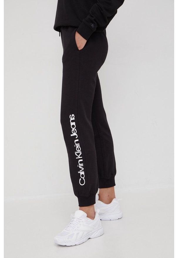 Calvin Klein Jeans spodnie dresowe bawełniane J20J218703.PPYY damskie kolor czarny z nadrukiem. Stan: podwyższony. Kolor: czarny. Materiał: bawełna, dresówka. Wzór: nadruk