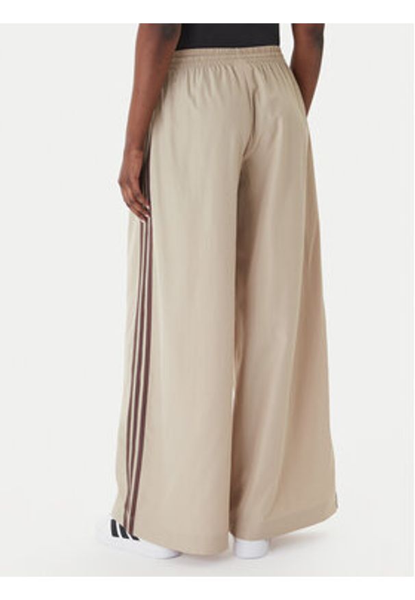 Adidas - adidas Spodnie dresowe Firebird Adilenium KD6300 Beżowy Regular Fit. Kolor: beżowy. Materiał: syntetyk
