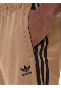 Adidas - adidas Spodnie dresowe adicolor Firebird JY1419 Beżowy Baggy Fit. Kolor: beżowy. Materiał: bawełna