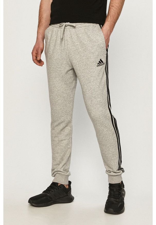 Adidas - adidas - Spodnie. Okazja: na co dzień. Kolor: szary. Materiał: dzianina, poliester. Wzór: nadruk, melanż. Styl: casual