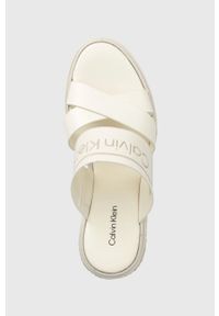 Calvin Klein klapki WEDGE 50HH - HE damskie kolor biały na koturnie HW0HW01498. Kolor: biały. Materiał: materiał, skóra, guma, włókno. Wzór: nadruk. Obcas: na koturnie #5