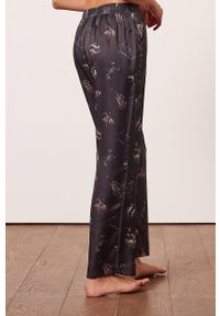 Etam spodnie piżamowe Asthro damskie kolor czarny satynowa. Kolor: czarny. Materiał: satyna. Wzór: ze splotem
