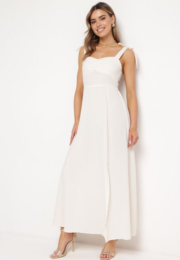 Born2be - Jasnobeżowa Rozkloszowana Sukienka na Wiązanych Ramiączkach z Rozcięciem Kalora. Kolor: beżowy. Materiał: tkanina. Długość rękawa: na ramiączkach. Wzór: gładki. Długość: maxi