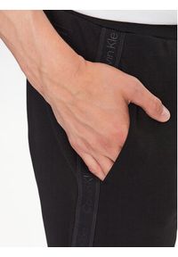 Calvin Klein Spodnie dresowe Logo Tape K10K111565 Czarny Comfort Fit. Kolor: czarny. Materiał: bawełna, dresówka, syntetyk #4