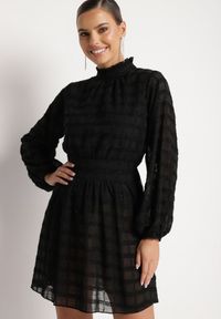 Born2be - Czarna Połyskująca Sukienka o Rozkloszowanym Kroju ze Stójką i Elastyczną Gumką w Pasie Venaraelle. Typ kołnierza: kołnierzyk stójkowy. Kolor: czarny. Wzór: aplikacja. Typ sukienki: rozkloszowane. Styl: klasyczny #1