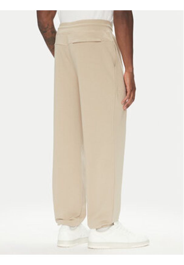 Guess Spodnie dresowe U5RB00 KCO31 Beżowy Regular Fit. Kolor: beżowy. Materiał: bawełna