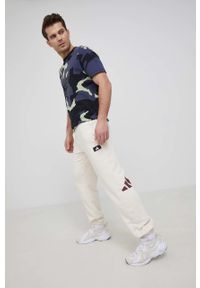 adidas Performance spodnie męskie kolor beżowy z nadrukiem. Kolor: beżowy. Materiał: materiał, dzianina. Wzór: nadruk