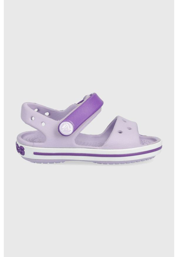 Crocs sandały dziecięce kolor fioletowy. Zapięcie: rzepy. Kolor: fioletowy. Materiał: guma, materiał. Wzór: gładki. Obcas: na obcasie. Wysokość obcasa: niski