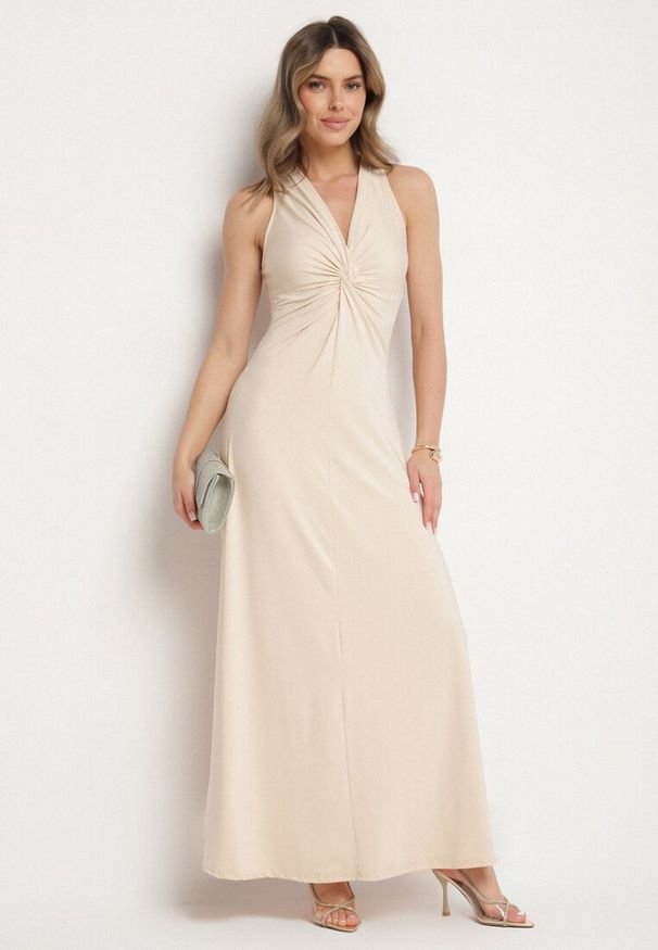 Born2be - Jasnobeżowa Rozkloszowana Sukienka Bez Rękawów z Wiskozą Zdobiona Marszczeniem Folenissa. Okazja: na imprezę. Typ kołnierza: dekolt w kształcie V, kokarda. Kolor: beżowy. Materiał: wiskoza. Długość rękawa: bez rękawów. Wzór: aplikacja. Typ sukienki: rozkloszowane