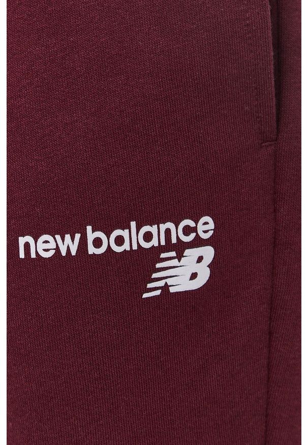 New Balance - Spodnie. Kolor: czerwony. Materiał: dzianina