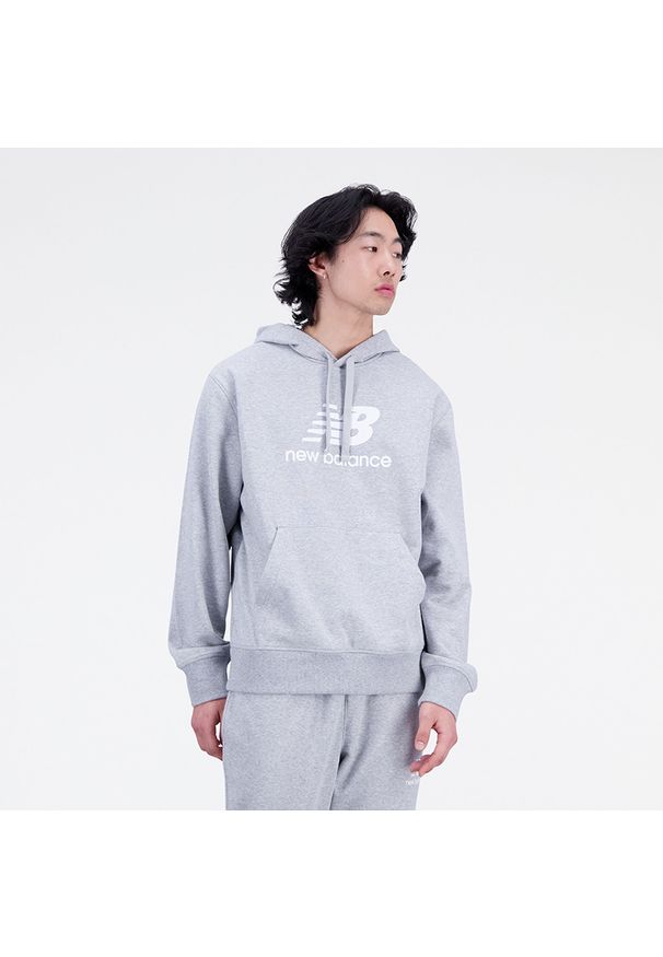Bluza męska New Balance MT31537AG – szara. Typ kołnierza: kaptur. Kolor: szary. Materiał: dresówka, bawełna, prążkowany, poliester. Wzór: napisy