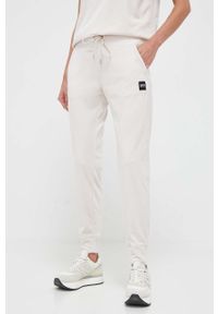 DKNY - Dkny spodnie dresowe kolor beżowy gładkie. Kolor: beżowy. Materiał: dresówka. Wzór: gładki #1