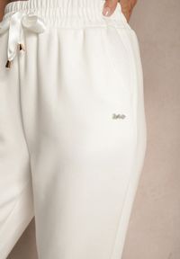 Renee - Białe Spodnie Dresowe z Ozdobną Wstążką i Metaliczną Nicią Evelzia. Okazja: na co dzień, na spacer. Kolor: biały. Materiał: dresówka. Styl: casual, elegancki