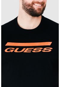 Guess - GUESS Czarny t-shirt męski z pomarańczowym logo. Kolor: czarny