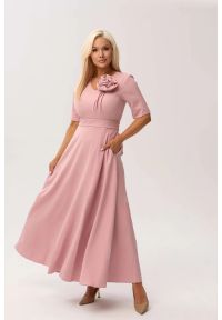 Moda Size Plus Iwanek - Sukienka MAXI Mirabella w odcieniu pudrowego różu z delikatną poświatą srebra OVERSIZE PLUS SIZE XXL WIOSNA LATO. Okazja: na urodziny, na wesele, na komunię, na ślub cywilny, na imprezę. Typ kołnierza: dekolt w kształcie V, kokarda. Kolekcja: plus size. Kolor: różowy. Wzór: kwiaty. Typ sukienki: oversize, dla puszystych. Materiał: tkanina, materiał, poliester, elastan. Sezon: lato, wiosna. Styl: elegancki, klasyczny. Długość: maxi #1