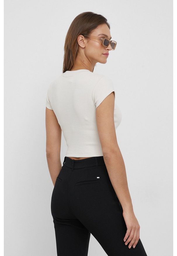 Calvin Klein Jeans t-shirt damski kolor beżowy. Kolor: beżowy. Materiał: lycra. Długość rękawa: krótki rękaw. Długość: krótkie. Wzór: aplikacja