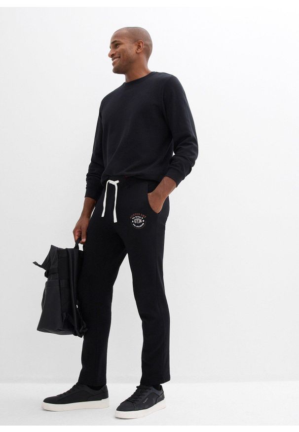 bonprix - Spodnie sportowe z czystej bawełny, ze sportowymi detalami. Kolor: czarny. Materiał: bawełna. Wzór: nadruk. Styl: sportowy