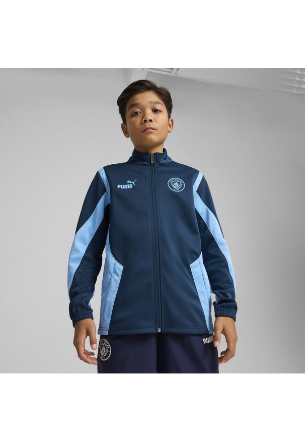Puma - Młodzieżowa kurtka Manchester City ftblNRGY+ PUMA Marine Blue Blazing. Kolor: niebieski. Wzór: aplikacja. Sport: piłka nożna