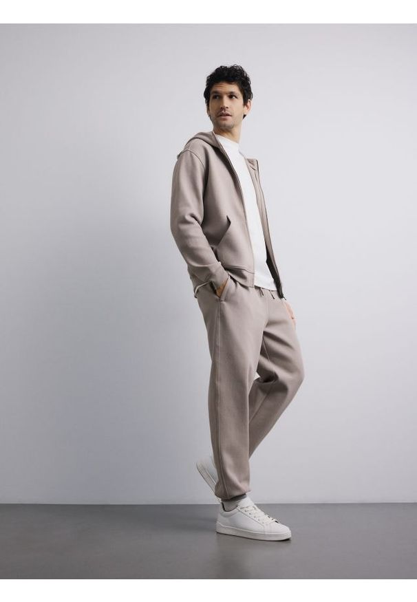Reserved - Spodnie dresowe comfort fit - beżowy. Kolor: beżowy. Materiał: dresówka