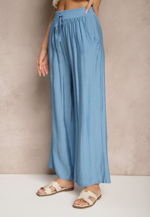Renee - Niebieskie Spodnie Typu Palazzo o Szerokim Kroju High Waist Ozdobione Wiązaniem Yaslevia. Okazja: na co dzień. Stan: podwyższony. Kolor: niebieski. Wzór: aplikacja. Styl: casual, elegancki