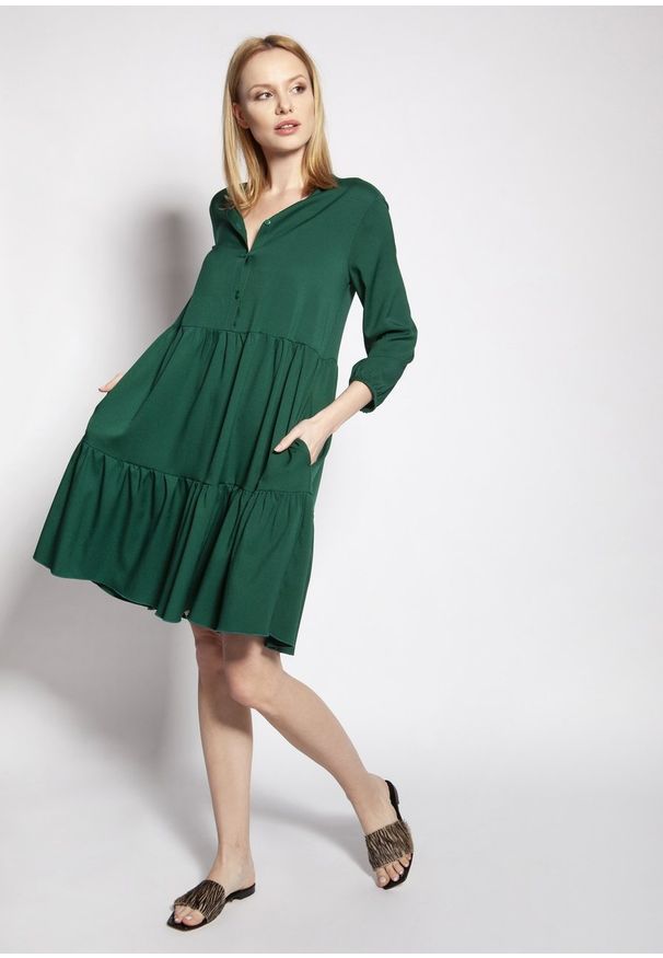 e-margeritka - Sukienka trapezowa koszulowa z falbanami zielona - 38/40. Kolekcja: moda ciążowa. Kolor: zielony. Materiał: tkanina, materiał, wiskoza. Sezon: lato. Typ sukienki: trapezowe, koszulowe