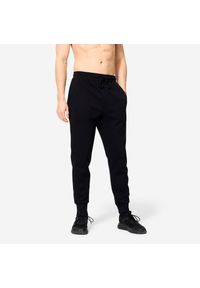 DOMYOS - Spodnie fitness męskie Domyos Gym & Pilates slim. Kolor: czarny. Materiał: dresówka, dzianina, materiał. Wzór: ze splotem. Sport: joga i pilates, fitness