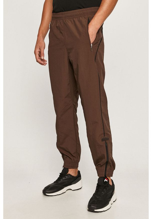 adidas Originals - Spodnie. Kolor: brązowy. Materiał: tkanina, nylon, materiał, poliester. Wzór: gładki