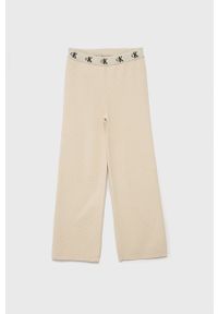 Calvin Klein Jeans Spodnie dziecięce kolor beżowy gładkie. Okazja: na co dzień. Kolor: beżowy. Materiał: dzianina. Wzór: gładki. Styl: casual