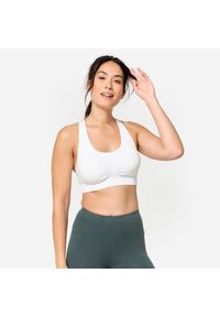 Decathlon - Stanik sportowy Kimjaly. Kolor: biały. Materiał: materiał, poliamid, skóra, elastan. Rodzaj stanika: wyciągane miseczki. Sport: joga i pilates
