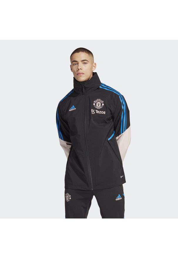 Kurtka do piłki nożnej męska Adidas Manchester United Condivo 22 Storm. Kolor: czarny, różowy, wielokolorowy. Materiał: materiał