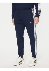 Adidas - adidas Spodnie dresowe adicolor 3-Stripes IM9319 Granatowy Slim Fit. Kolor: niebieski. Materiał: syntetyk