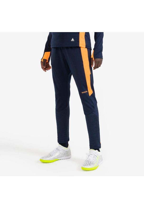 KIPSTA - Spodnie piłkarskie dla dzieci Kipsta CLR. Kolor: wielokolorowy, niebieski, pomarańczowy. Materiał: skóra. Sport: piłka nożna