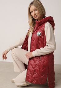 Born2be - Czerwona Przejściowa Kamizelka Pikowana o Długim Kroju z Kapturem i Naszywką Harmaste. Okazja: na co dzień. Typ kołnierza: kaptur. Kolor: czerwony. Materiał: jeans. Długość: długie. Wzór: aplikacja. Styl: casual #1