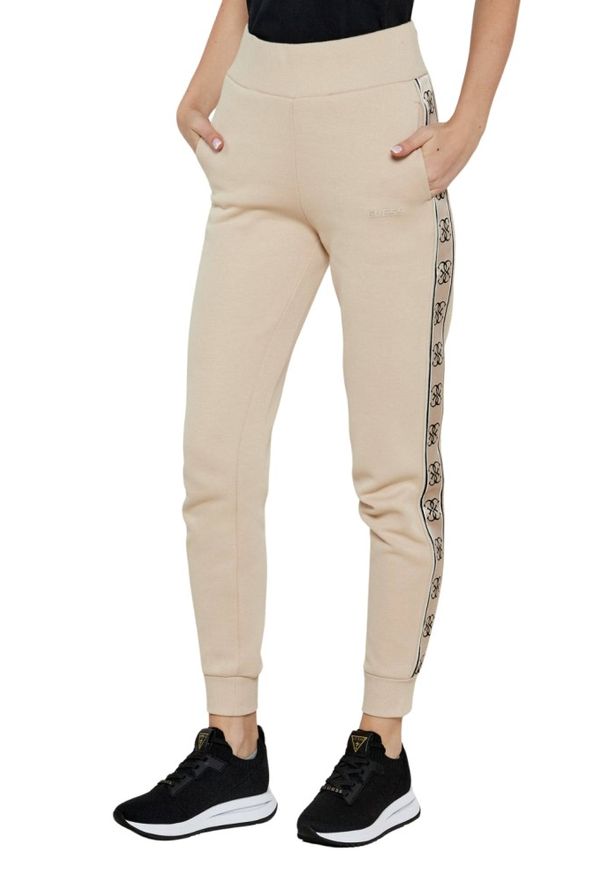 Guess - GUESS Beżowe spodnie dresowe damskie Britney. Kolor: beżowy. Materiał: dresówka