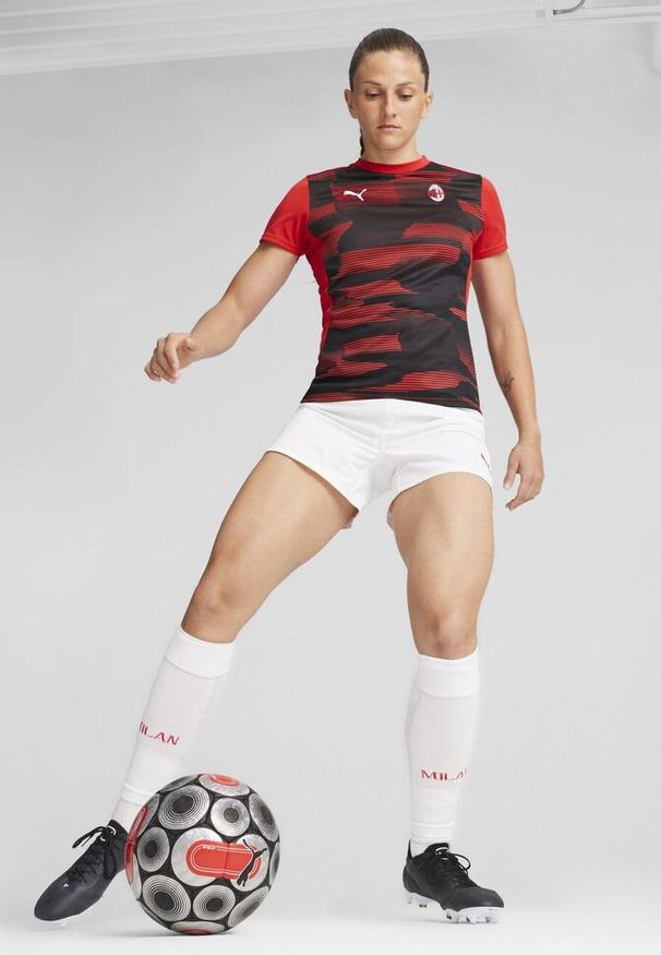 Puma - Damska koszulka przedmeczowa z krótkim rękawem AC Milan PUMA. Kolor: czarny, czerwony, wielokolorowy. Długość rękawa: krótki rękaw. Długość: krótkie