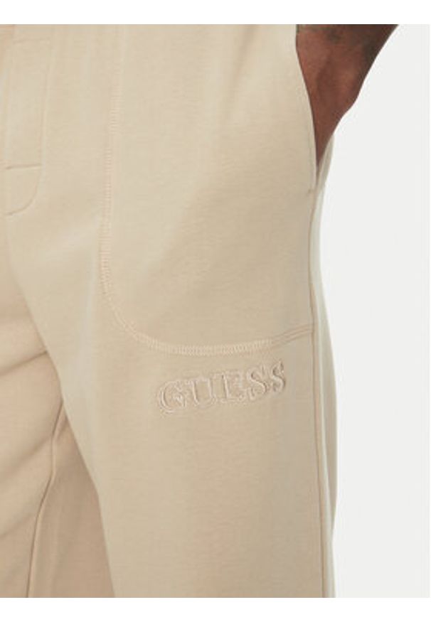 Guess Spodnie dresowe U5RB00 KCO31 Beżowy Regular Fit. Kolor: beżowy. Materiał: bawełna