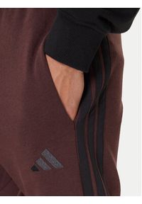 Adidas - adidas Spodnie dresowe Essentials 3-Stripes JX0749 Brązowy Regular Fit. Kolor: brązowy. Materiał: bawełna #4