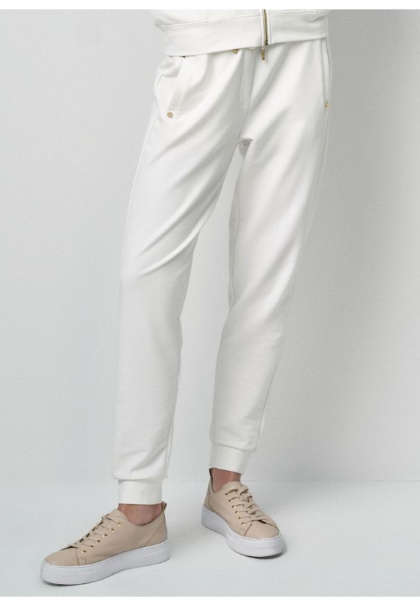 Ochnik - Kremowe dresowe spodnie damskie. Kolor: biały. Materiał: bawełna