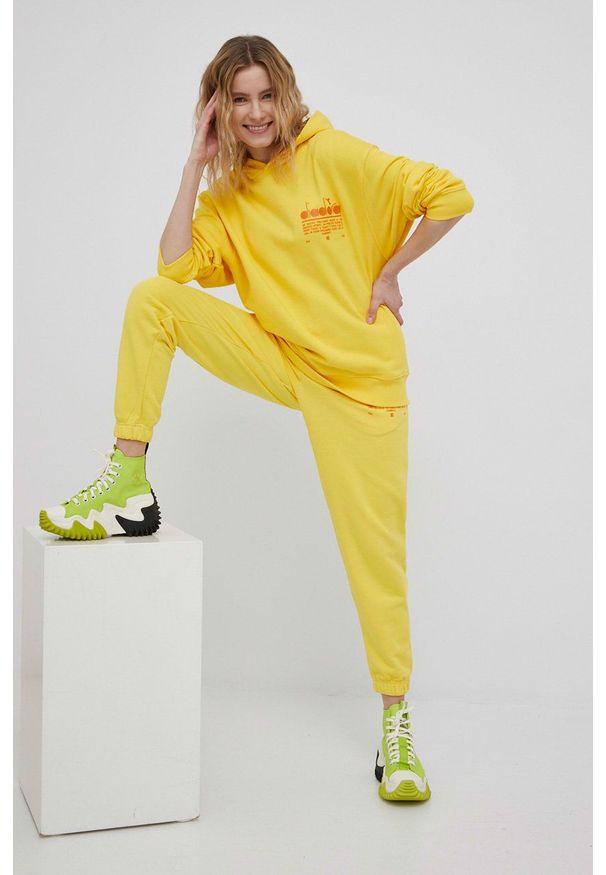 Diadora bluza bawełniana kolor żółty z kapturem z nadrukiem. Typ kołnierza: kaptur. Kolor: żółty. Materiał: bawełna. Wzór: nadruk