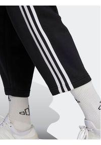 Adidas - adidas Spodnie dresowe Essentials 3-Stripes Open Hem Fleece HZ5748 Czarny Loose Fit. Kolor: czarny. Materiał: bawełna