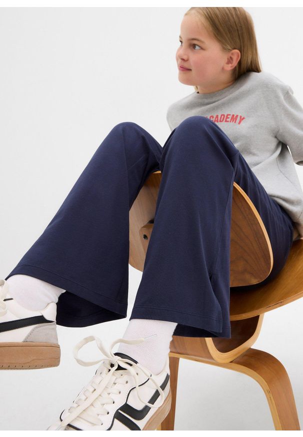 bonprix - Spodnie z poszerzaną nogawką z mieszanki bawełny organicznej z rozcięciami po bokach. Kolor: niebieski. Materiał: bawełna