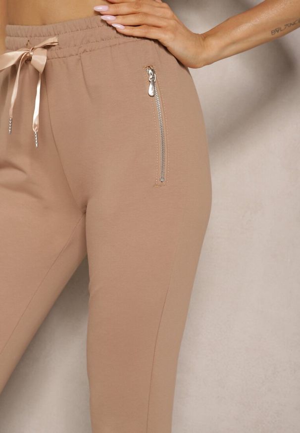 Renee - Ciemnobeżowe Spodnie Dresowe z Bawełny o Kroju Jogger High Waist Cherisa. Okazja: na co dzień. Stan: podwyższony. Kolor: beżowy. Materiał: dresówka, bawełna. Styl: elegancki, casual