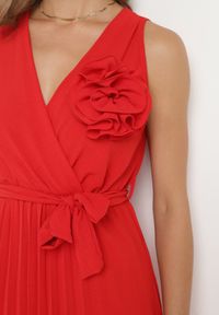 Born2be - Czerwona Plisowana Sukienka z Paskiem i Gumką w Talii Ozdobiona Broszką Kwiatem Vikmirra. Okazja: na randkę, na imprezę, na wesele, na ślub cywilny. Typ kołnierza: dekolt w kształcie V. Kolor: czerwony. Wzór: aplikacja, kwiaty. Styl: klasyczny, elegancki #6