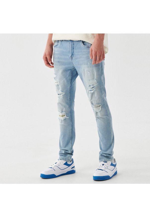 Cropp - Jeansy skinny z postrzępieniami - Niebieski. Kolor: niebieski